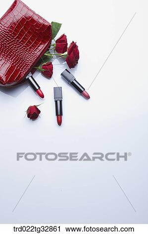 Stock Image - Red lipstick and rose in the red pouch. Fotosearch