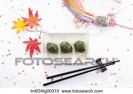 Stock Image - Rice cake, chopsticks, traditional clothes accessory, and a fan. Fotosearch