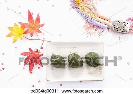 Stock Image - Rice cake, traditional clothes accessory, and a fan. Fotosearch