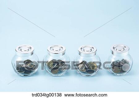 Stock Photo - saving coins in glass bottle. Fotosearch