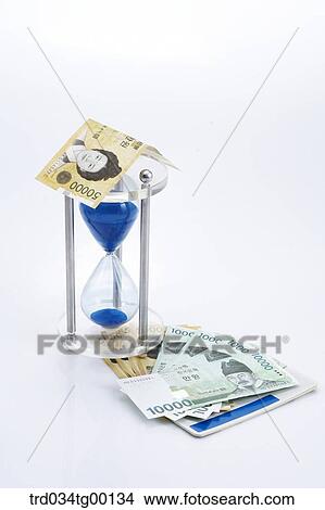 spreaded money bills and hour glass View Large Photo Image Picture - spreaded money bills and hour glass. Fotosearch