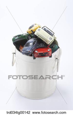 Stock Image - waste bucket is filled with miniature cars. Fotosearch