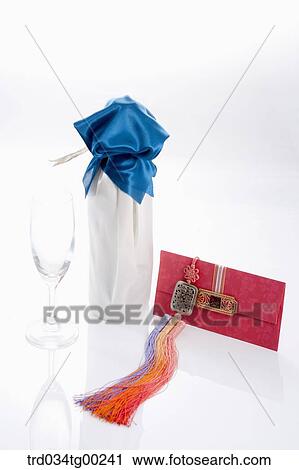 Stock Image - Wrapped bottles, a glass, and red envelope . Fotosearch