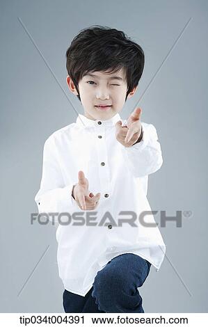 Stock Image - a boy in white shirt posing while winking. Fotosearch