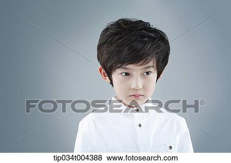 Stock Photo - a boy in white shirt staring. Fotosearch