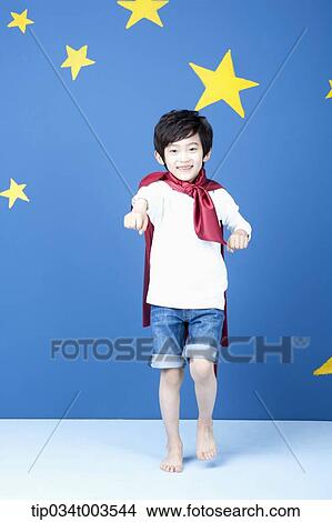 a boy posing like a superman with a red cape around his neck View Large Photo Image Picture - a boy posing like a superman with a red cape around his neck. Fotosearch