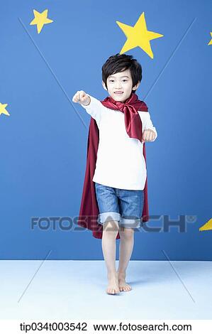 a boy posing like a superman with a red cape around his neck View Large Photo Image Stock Image - a boy posing like a superman with a red cape around his neck. Fotosearch