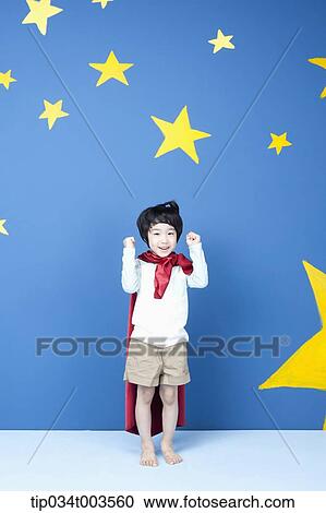 Stock Image - a boy wearing a red cape raising two arms . Fotosearch