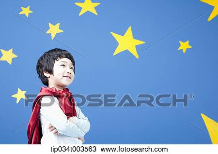 a boy wearing a red cape standing with arms crossed in front of a blue wall full of stars View Large Photo Image Stock Image - a boy wearing a red cape standing with arms crossed in front of a blue wall full of stars. Fotosearch