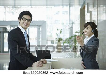 a businessman and help desk woman smiling at camera View Large Photo Image Stock Image - a businessman and help desk woman smiling at camera . Fotosearch