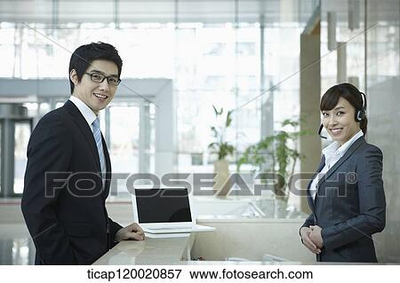 a businessman and help desk woman smiling at camera View Large Photo Image Stock Photo - a businessman and help desk woman smiling at camera . Fotosearch
