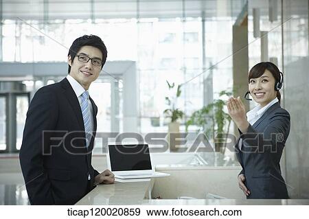 a businessman and help desk woman smiling at camera View Large Photo Image Stock Photo - a businessman and help desk woman smiling at camera . Fotosearch