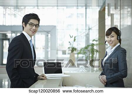 a businessman and help desk woman smiling at camera View Large Photo Image Stock Photograph - a businessman and help desk woman smiling at camera . Fotosearch