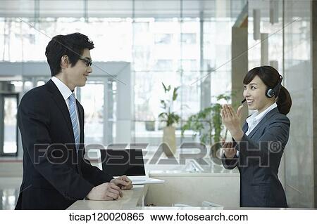 a businessman and help desk woman talking in a office building View Large Photo Image Stock Photography - a businessman and help desk woman talking in a office building . Fotosearch