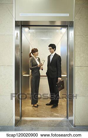 a businessman and woman discussing in elevator View Large Photo Image Stock Image - a businessman and woman discussing in elevator. Fotosearch