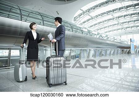 Stock Image - a businessman and woman discussing in Incheon airport. Fotosearch