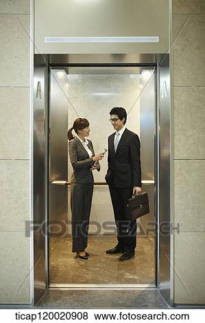 a businessman and woman discussing in elevator View Large Photo Image Stock Photo - a businessman and woman discussing in elevator. Fotosearch