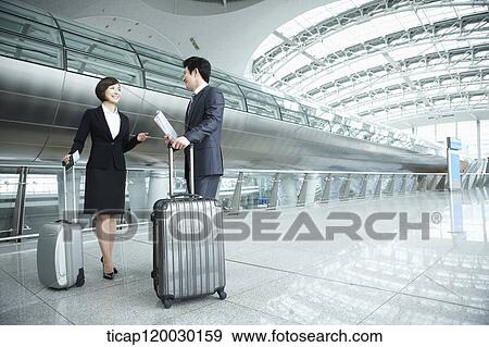 Stock Photo - a businessman and woman discussing in Incheon airport. Fotosearch