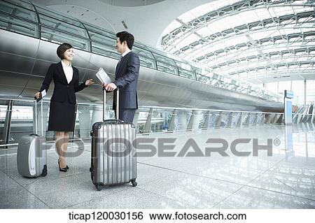 Stock Photograph - a businessman and woman discussing in Incheon airport. Fotosearch
