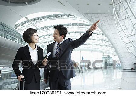 a businessman and woman discussing while man pointing at something in Incheon airport View Large Photo Image Stock Image - a businessman and woman discussing while man pointing at something in Incheon airport. Fotosearch