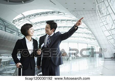 a businessman and woman discussing while man pointing at something in Incheon airport View Large Photo Image Stock Image - a businessman and woman discussing while man pointing at something in Incheon airport. Fotosearch