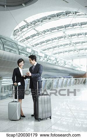 Stock Photo - a businessman and woman discussing with document in Incheon airport. Fotosearch