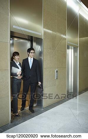 a businessman and woman getting of an elevator View Large Photo Image Stock Image - a businessman and woman getting of an elevator. Fotosearch