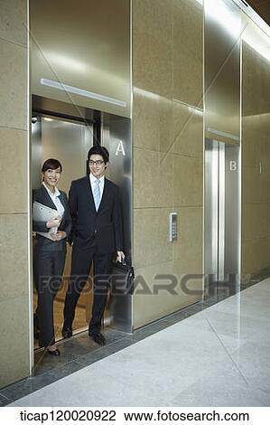 a businessman and woman getting of an elevator View Large Photo Image Stock Image - a businessman and woman getting of an elevator. Fotosearch