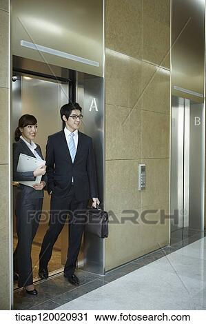 a businessman and woman getting of an elevator View Large Photo Image Stock Image - a businessman and woman getting of an elevator. Fotosearch