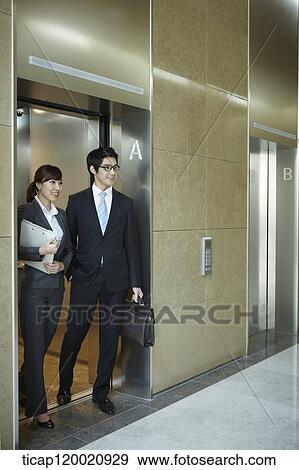 a businessman and woman getting of an elevator View Large Photo Image Stock Photo - a businessman and woman getting of an elevator. Fotosearch