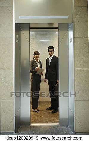 a businessman and woman in a closing elevator View Large Photo Image Stock Photo - a businessman and woman in a closing elevator . Fotosearch