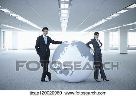 a businessman and woman leaning on a huge globe in an empty room View Large Photo Image Stock Image - a businessman and woman leaning on a huge globe in an empty room. Fotosearch