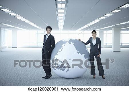 a businessman and woman leaning on a huge globe in an empty room View Large Photo Image Stock Image - a businessman and woman leaning on a huge globe in an empty room. Fotosearch