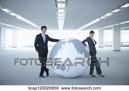 a businessman and woman leaning on a huge globe in an empty room View Large Photo Image Stock Photo - a businessman and woman leaning on a huge globe in an empty room. Fotosearch