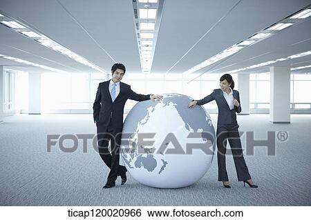 a businessman and woman leaning on a huge globe in an empty room View Large Photo Image Stock Photograph - a businessman and woman leaning on a huge globe in an empty room. Fotosearch