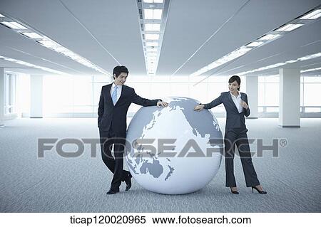 a businessman and woman leaning on a huge globe in an empty room View Large Photo Image Stock Photography - a businessman and woman leaning on a huge globe in an empty room. Fotosearch
