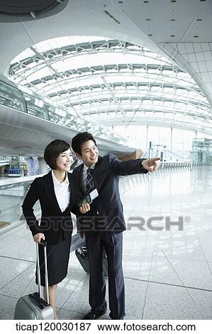 a businessman and woman looking at something together in Incheon airport View Large Photo Image Stock Photo - a businessman and woman looking at something together in Incheon airport. Fotosearch