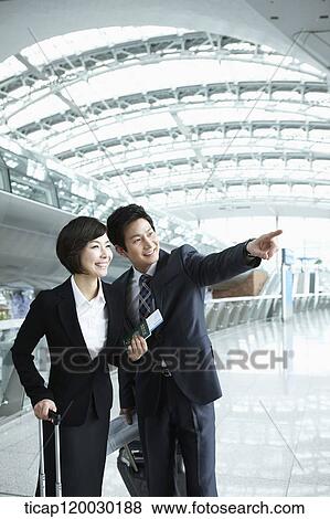 Stock Photo - a businessman and woman looking at something together in Incheon airport. Fotosearch