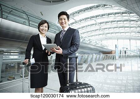 a businessman and woman smiling at camera in Incheon airport View Large Photo Image Picture - a businessman and woman smiling at camera in Incheon airport. Fotosearch