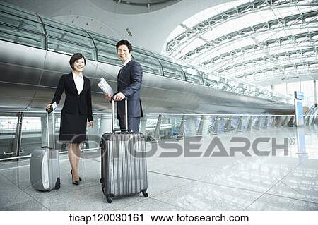 Stock Image - a businessman and woman smiling at camera in Incheon airport. Fotosearch