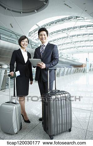 a businessman and woman smiling at camera in Incheon airport View Large Photo Image Stock Photo - a businessman and woman smiling at camera in Incheon airport. Fotosearch