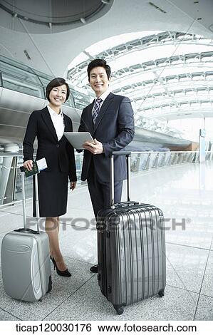 Stock Photograph - a businessman and woman smiling at camera in Incheon airport. Fotosearch