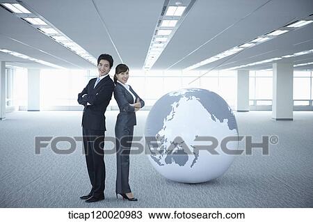 a businessman and woman standing back to back next to a huge globe View Large Photo Image Stock Image - a businessman and woman standing back to back next to a huge globe. Fotosearch