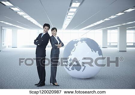 a businessman and woman standing back to back next to a huge globe View Large Photo Image Stock Photo - a businessman and woman standing back to back next to a huge globe. Fotosearch