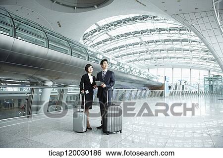 a businessman and woman standing with luggage in Incheon airport View Large Photo Image Stock Photograph - a businessman and woman standing with luggage in Incheon airport. Fotosearch
