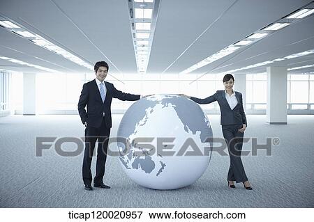a businessman and woman touching a huge globe in an empty room View Large Photo Image Stock Photo - a businessman and woman touching a huge globe in an empty room. Fotosearch