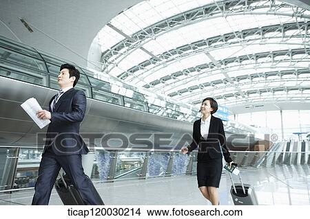 a businessman and woman walking fast in Incheon airport View Large Photo Image Picture - a businessman and woman walking fast in Incheon airport. Fotosearch