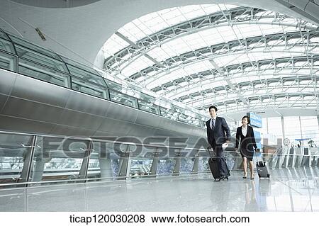 a businessman and woman walking fast in Incheon airport View Large Photo Image Stock Photo - a businessman and woman walking fast in Incheon airport. Fotosearch
