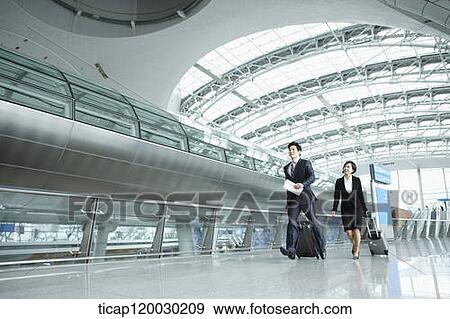 a businessman and woman walking fast in Incheon airport View Large Photo Image Stock Photo - a businessman and woman walking fast in Incheon airport. Fotosearch