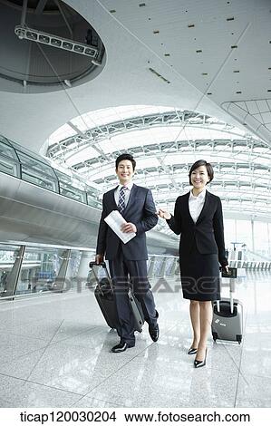 Picture - a businessman and woman walking together in Incheon airport. Fotosearch